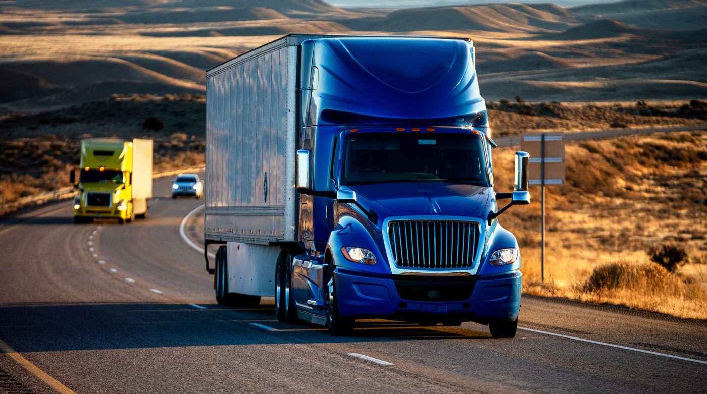 Two-semi-trucks-and-a-passenger-vehicle-on-a-highway
