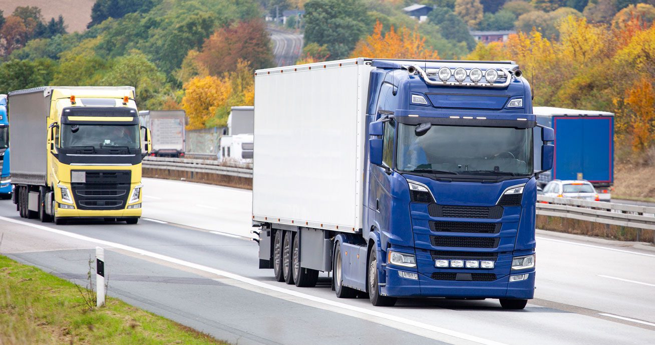 Blue-and-yellow-trucks-driving-on-highway-with-other-vehicles