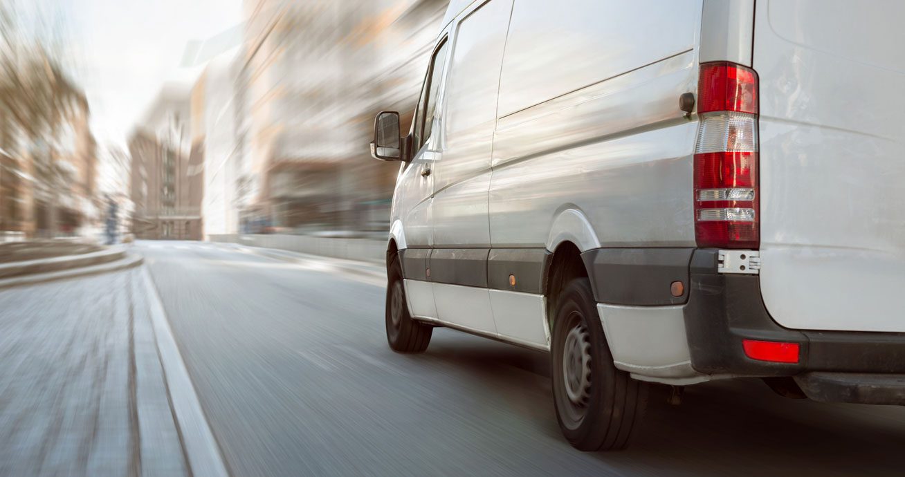 Fast-moving-white-van-on-a-bright-street