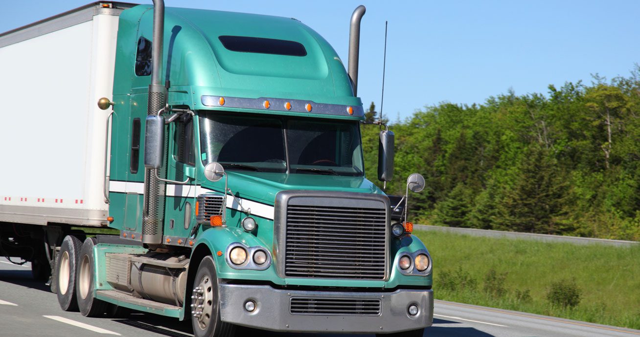 Front-view-of-semi-truck-driving-along-roadway