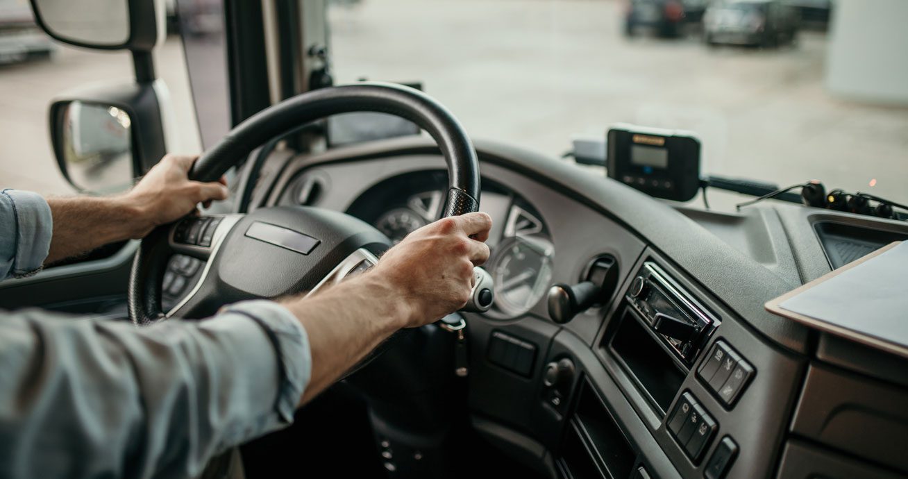 Hands-on-steering-wheel-inside-truck-cab