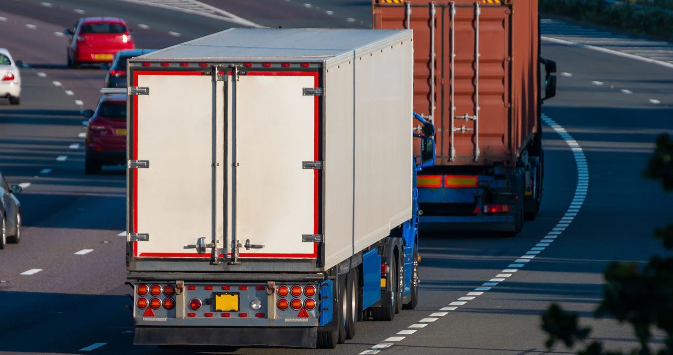 Multiple-trucks-driving-along-highway-lanes-in-same-direction