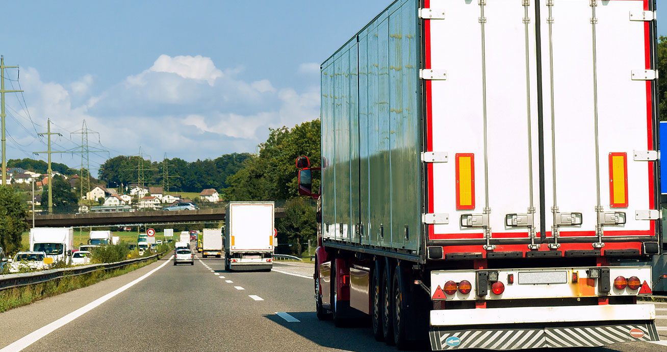 Rear-view-of-semi-truck-driving-on-highway-with-other-vehicles-ahead