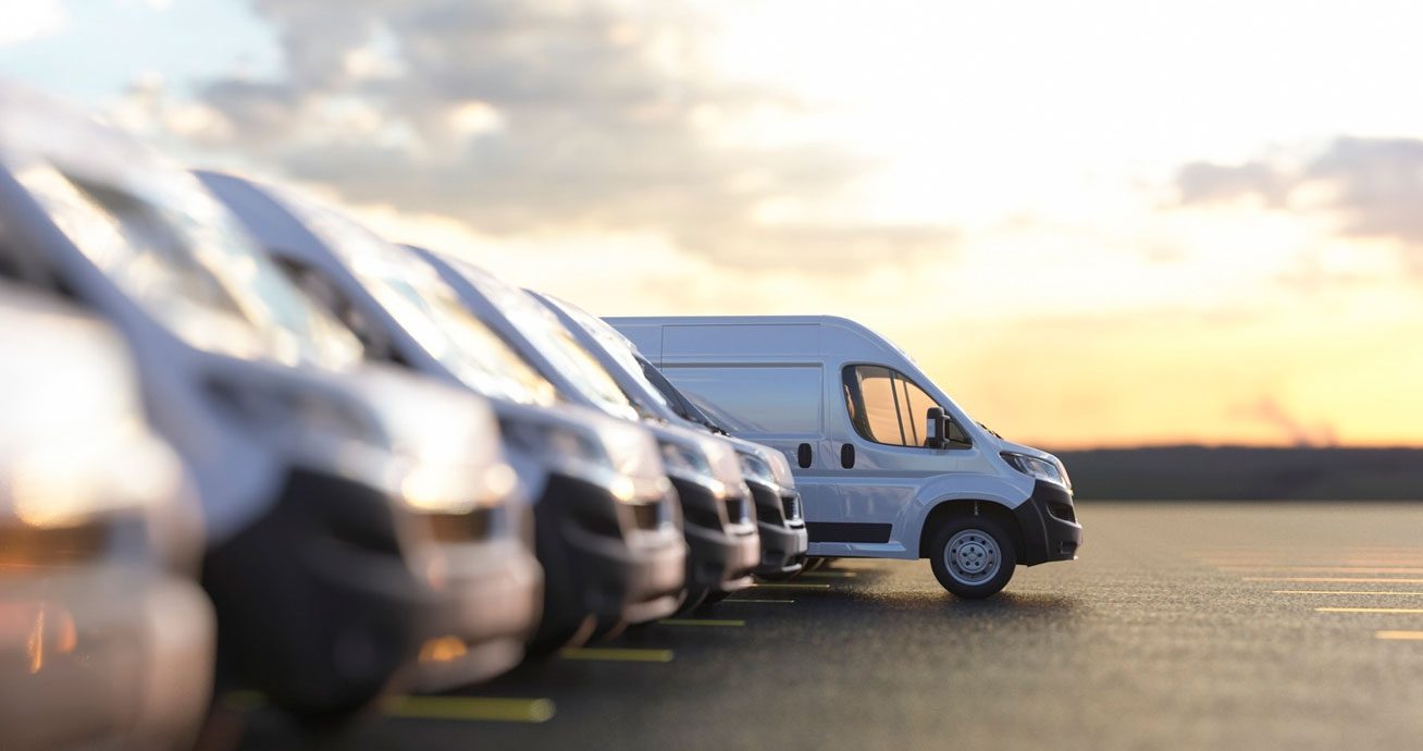 Row-of-white-vans-parked-side-by-side-in-a-line