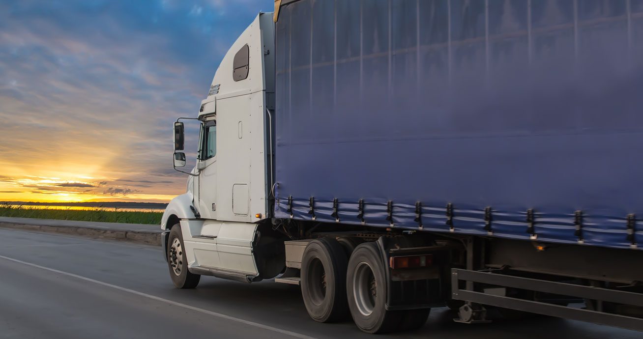 Semi-truck-driving-on-highway-with-trailer-attached