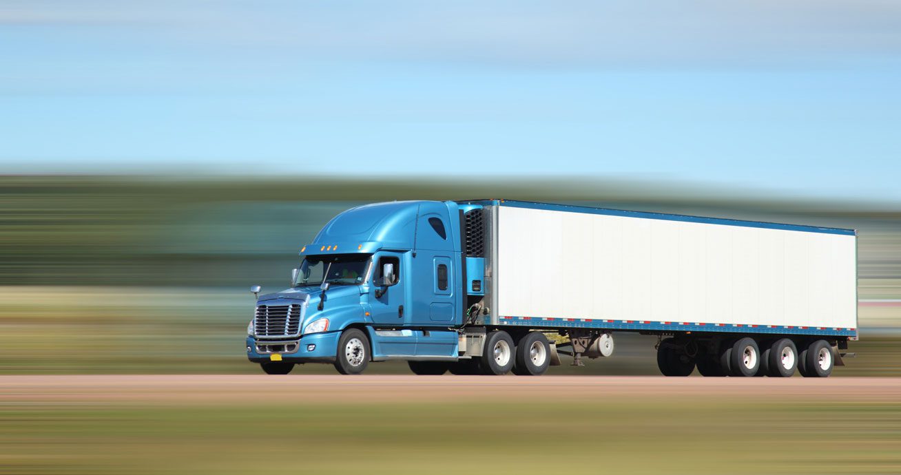 Semi-truck-moving-on-highway-with-blurred-surroundings-indicating-speed