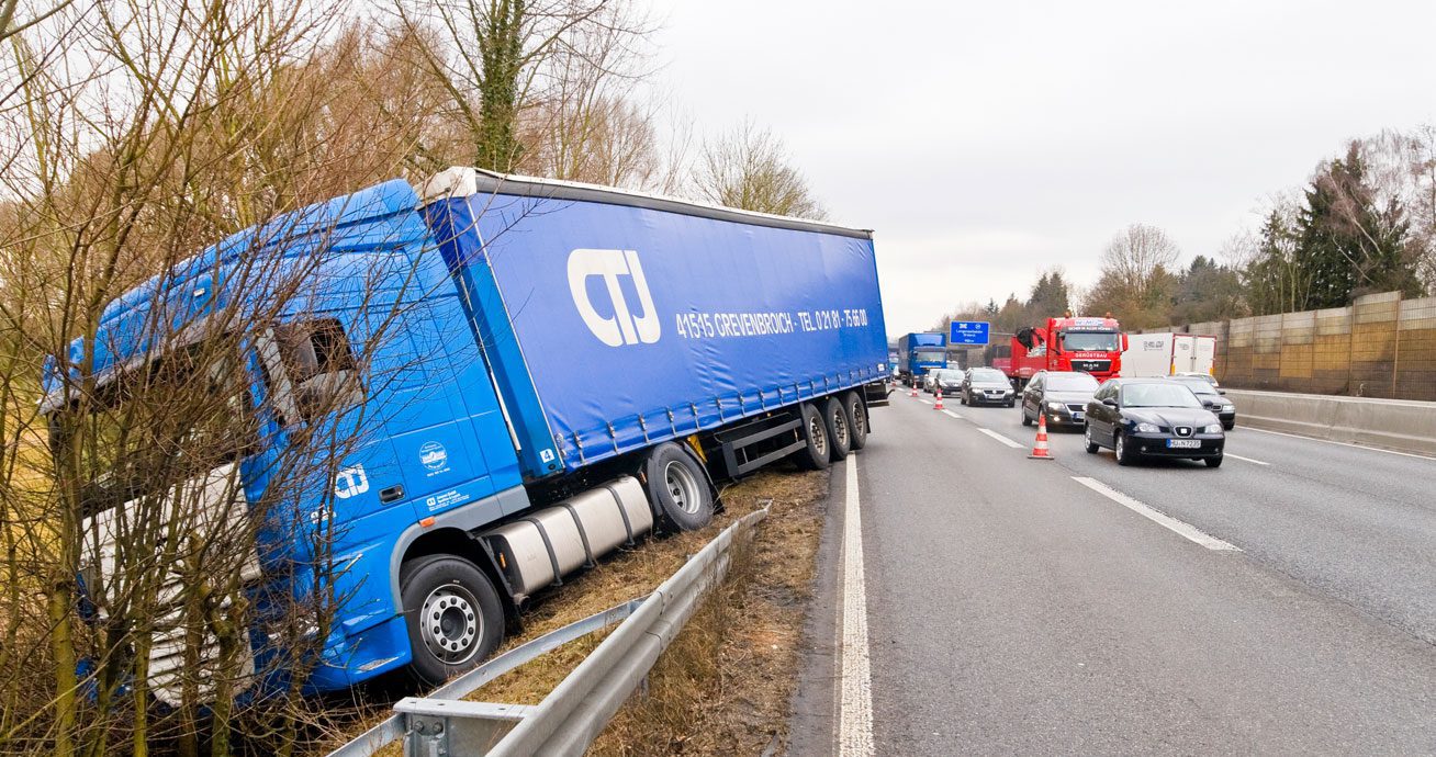 Truck-off-road-on-shoulder-with-traffic-and-cones-nearby
