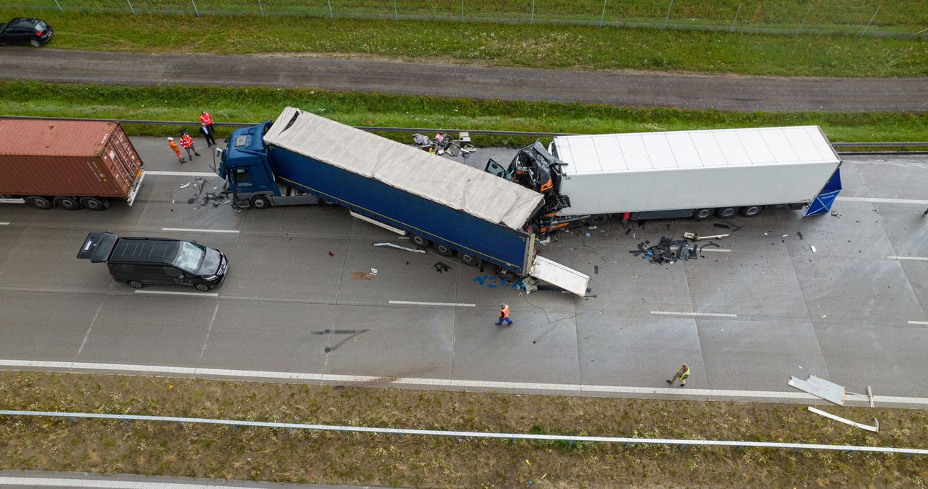 Aerial-view-of-crashed-semi-trucks-with-debris-scattered-on-highway