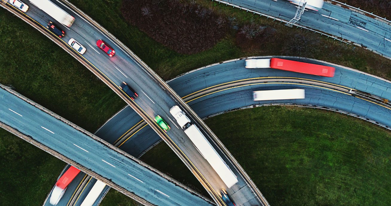 Aerial-view-of-highway-interchange-with-cars-and-trucks-on-curved-roads