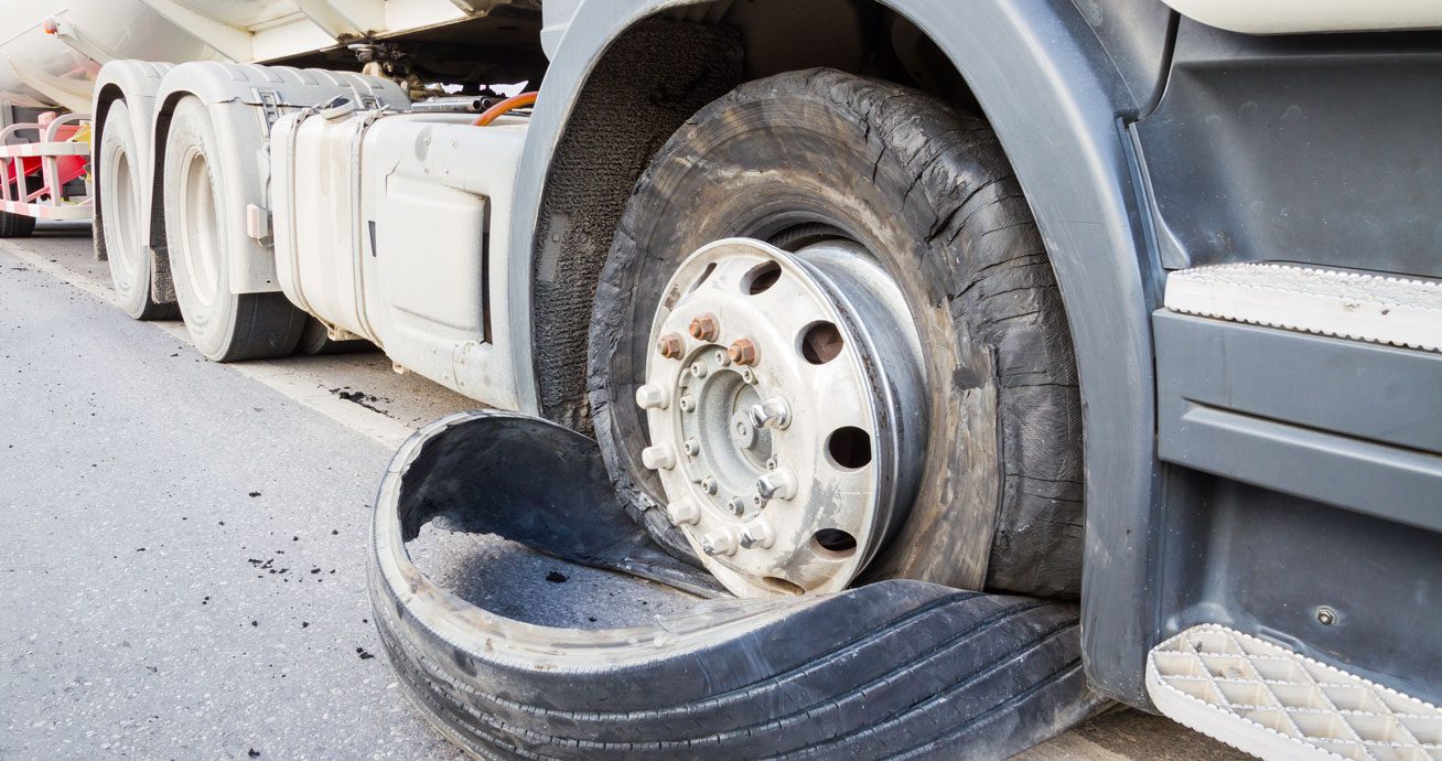 Flat-tire-on-truck-with-damaged-tire-on-road