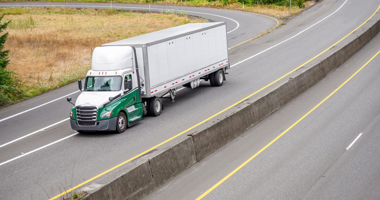 Side-view-of-semi-truck-pulling-box-trailer-on-road